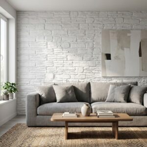 Sala de estar con revestimiento de pared interior Saqqara Blanco efecto piedra, sofá gris y mesa.