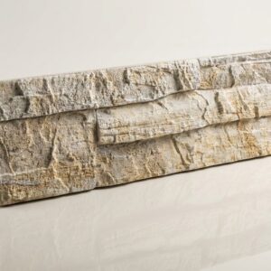 Panel de revestimiento de pared interior imitando piedra natural en tono marfil.