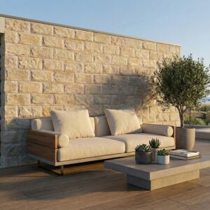 Revestimiento pared exterior efecto piedra Andros Beige en una terraza con sofá y olivo.