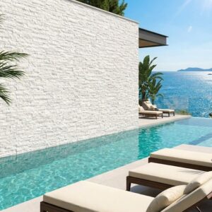 Revestimiento pared exterior blanco imitación piedra en fachada moderna con piscina y mar.