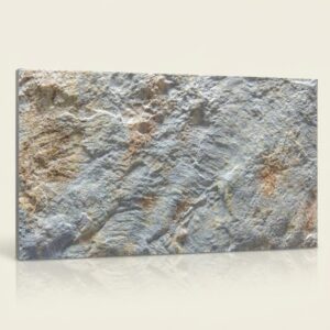 Azulejo moderno efecto piedra Volterra Perla con textura rugosa en tonos grises y tierra.