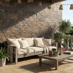 Espacio exterior con suelo de terraza de piedra rústica y mobiliario de jardín, con plantas y una pared de piedra en el fondo.