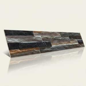 Pieza rectangular de revestimiento con textura rugosa, colores grises, marrones y negros, acabado natural. Presenta un patrón de veta irregular.