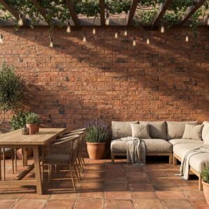 Un patio con revestimiento pared exterior efecto piedra Itaca Caldera, muebles y plantas.
